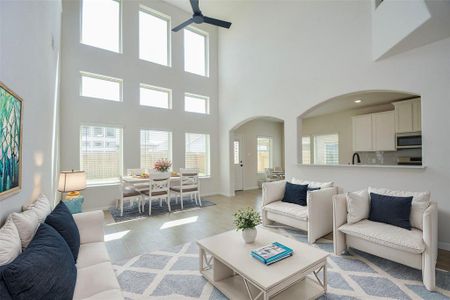 This expansive living area is a showstopper with its soaring ceilings and wall of windows, filling the room with abundant natural light. The open concept design connects the living space to the kitchen and dining area, making it perfect for entertaining guests or family gatherings.