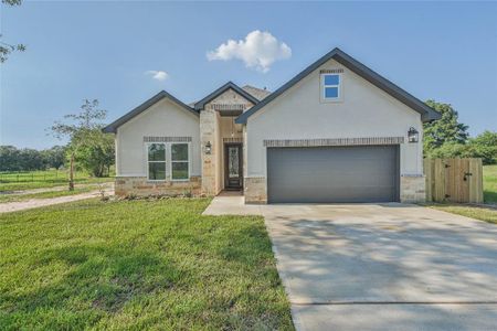 Two car garage with double driveway and stone/brick exterior accents.