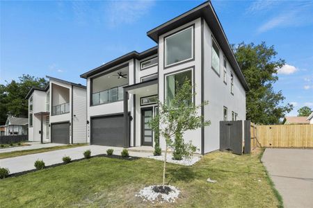 Contemporary house with a front lawn, a garage, and a balcony