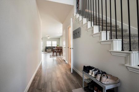 Hallway with hardwood / wood-style flooring and a towering ceiling