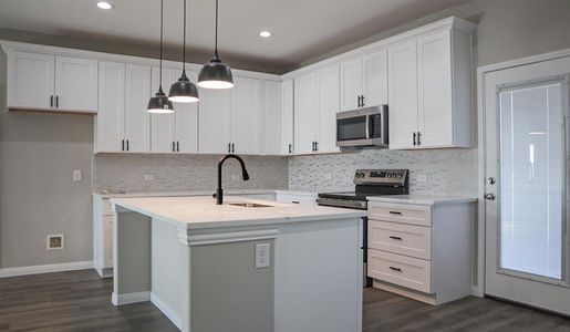 Kitchen with white cabinetry, stainless steel appliances, and sink