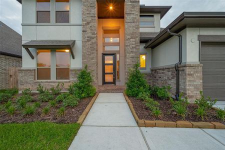 As you arrive, you'll be greeted by lovely landscaping and a charming front porch, complete with an impressive 8ft modern glass and wood entry door.