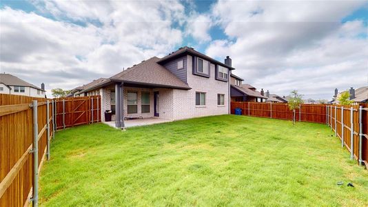 Back of house with a yard and a patio