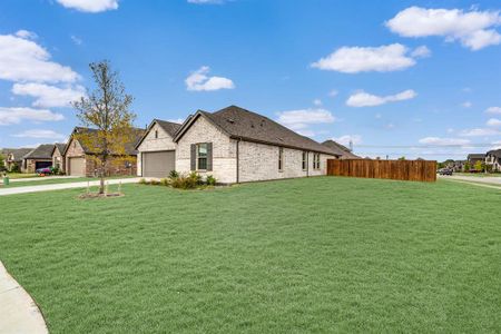 View of side of property with a yard and a garage