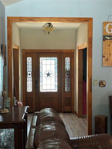 Entryway with lofted ceiling and hardwood / wood-style floors