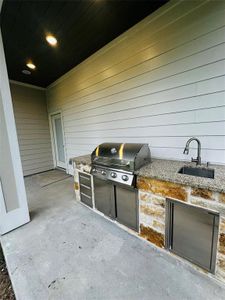 Outdoor kitchen with gas grill with sink/ice chest and stainless steel drawer. Easily entertain your guest with ceiling speakers and huge backyard.