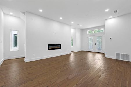 Unfurnished living room featuring french doors and dark hardwood / wood-style floors