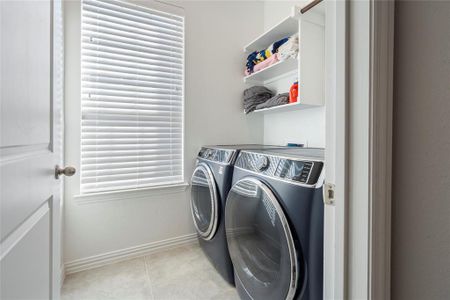 Laundry area with a healthy amount of sunlight, light tile, and conveniently located on the first floor.