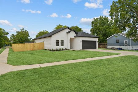 Ranch-style house featuring a garage and a front yard