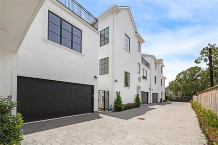 From the front entrance, the view extends down the driveway, flanked by meticulously manicured landscaping, leading to the gate.