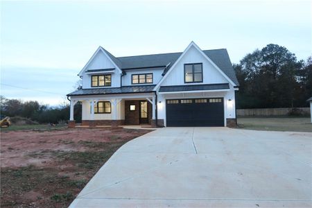 Modern inspired farmhouse with a garage and covered porch