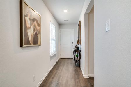 Hall featuring a wealth of natural light and dark hardwood / wood-style floors