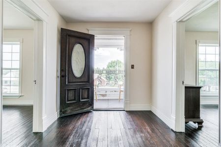 Foyer featuring plenty of natural light and dark wood-type flooring