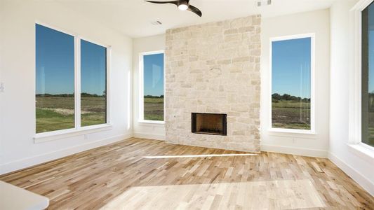 Unfurnished living room with ceiling fan, light wood-type flooring, and a fireplace