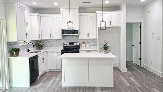 Kitchen featuring pendant lighting, light wood-type flooring, a center island, and appliances with stainless steel finishes