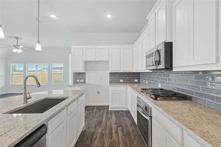 Kitchen featuring stainless steel appliances, dark hardwood / wood-style floors, sink, and white cabinetry