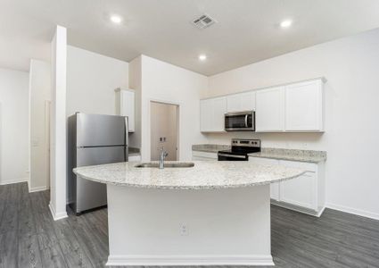 Stainless steel appliances and granite countertops fill the kitchen