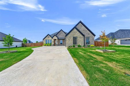 View of front of house featuring an oversized 3 car garage and a front lawn