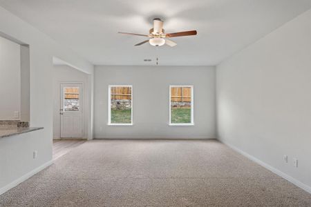 Living room with ceiling fan and light colored carpet