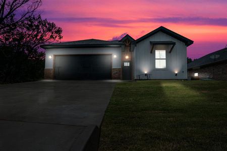 View of front of house with a lawn and a garage