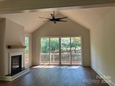 Living room with 14ft vaulted ceiling and 8ft quad window slider with access to the rear deck