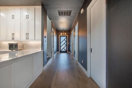 Corridor featuring a notable chandelier and wood-type flooring