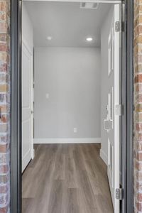 Entryway featuring wood-type flooring and brick wall