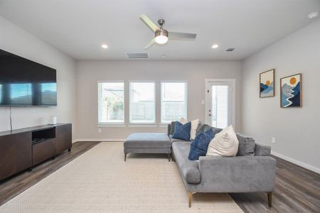 Living room area with a sectional couch, light decor, and large windows.