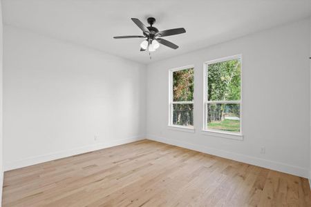 Spare room featuring ceiling fan, plenty of natural light, and light hardwood / wood-style floors