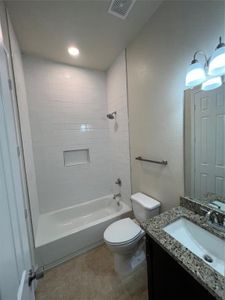 Full bathroom featuring tiled shower / bath, tile patterned floors, vanity, and toilet