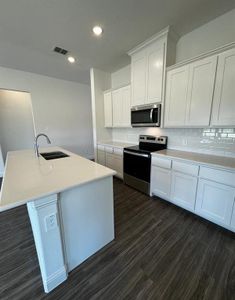 Kitchen featuring white cabinets, sink, a kitchen island with sink, stainless steel appliances, and dark hardwood / wood-style floors