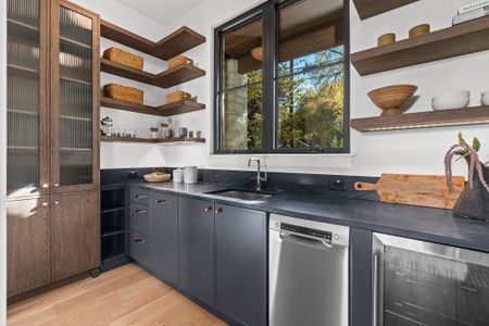 The butler's pantry offers a secondary kitchen space with a countertop, second sink, second dishwasher, a beverage center and plenty of storage, all of which can be closed off from the main kitchen for entertaining.