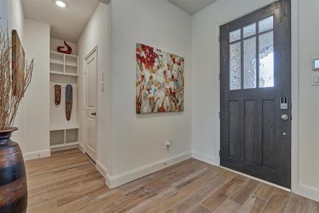 Lovely front door with beveled privacy glass and a mud rack to the side perfect to store all your keys, jackets and backpacks