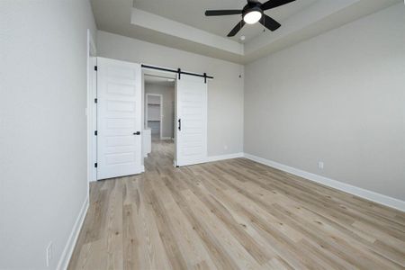 The master bedroom features tall barn doors, high ceilings and privacy.