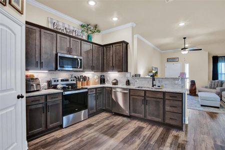 Kitchen has breakfast bar and stainless steel appliances.