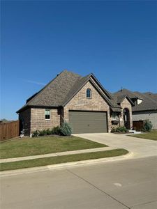 French country inspired facade featuring a front lawn and a garage