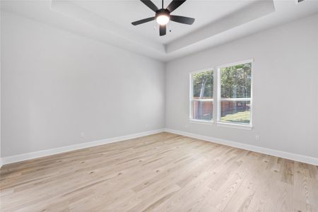 Spacious Master Bedroom with luxury vinyl flooring, ceiling fan, and two beautiful windows.