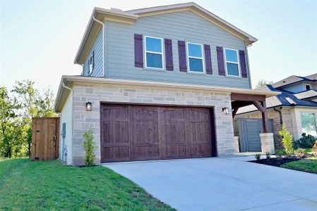 View of front facade featuring a garage and a front lawn