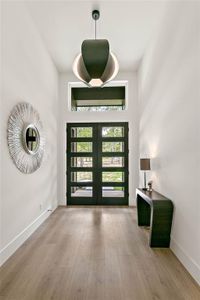 Gorgeous double doors let in the light and beauty of the wooded front yard.