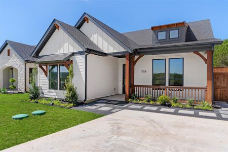 Modern inspired farmhouse featuring a front yard and a porch