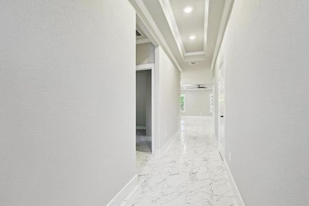 Hall with ornamental molding and light tile flooring