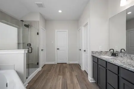 The master bathroom features large corner tub, walk-in shower, dual sink vanity, and his and her walk-in closets.