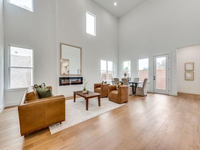 Living room featuring a towering ceiling and light wood-type flooring