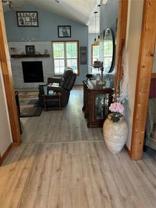 Hall featuring lofted ceiling, hardwood / wood-style flooring, and a textured ceiling