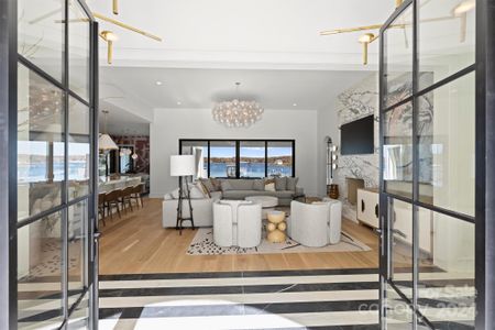 Iron & glass entry doors. Lake views. Living room.