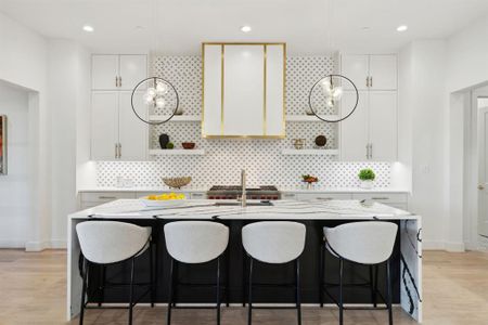 Kitchen featuring white cabinets, tasteful backsplash, light wood-type flooring, and a center island with sink