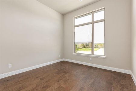 Spare room featuring dark hardwood / wood-style floors and a healthy amount of sunlight