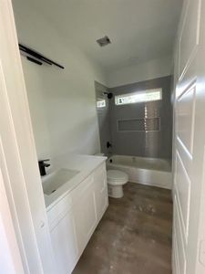 Full bathroom with concrete flooring, bathtub / shower combination, toilet, and vanity