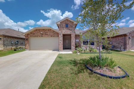 View of front facade featuring a garage and a front lawn