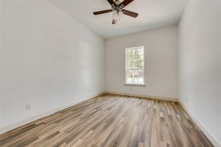Empty room with ceiling fan and wood-type flooring